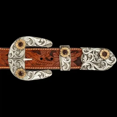 A custom western three piece belt buckle set featuring antiqued silver scrollwork and golden sunflowers 